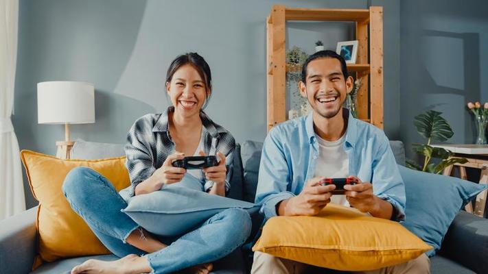 smiling couple playing video games home